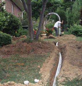 a Delray Beach irrigation repair specialist is laying pipes in the ground