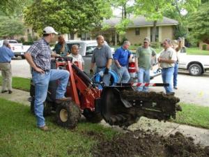 Delray Beach sprinkler installation team with a trencher